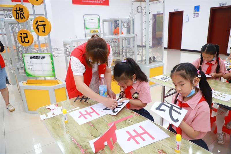 2021年7月10日，鄂州市科協(xié)組織落駕坪小學(xué)學(xué)生在鄂州市科技館開展社會主義核心價值觀系列活動，圖為開展的紅色剪影圓夢中華剪紙活動，志愿者指導(dǎo)同學(xué)們.jpg