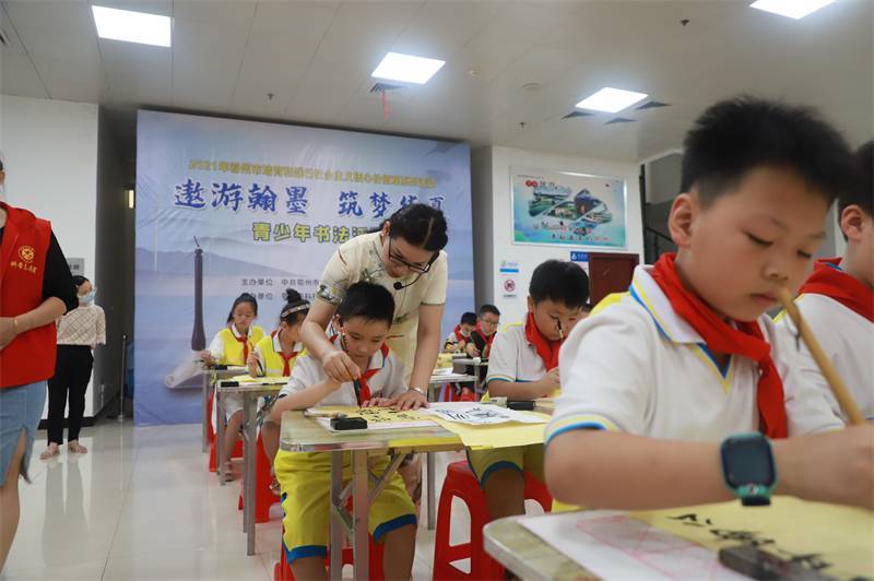 2021年7月10日，鄂州市科協(xié)組織蓮花小學(xué)學(xué)生在鄂州市科技館開展社會(huì)主義核心價(jià)值觀系列活動(dòng)，圖為開展的遨游翰墨筑夢(mèng)華夏書法活動(dòng)，老師指導(dǎo)學(xué)生.jpg